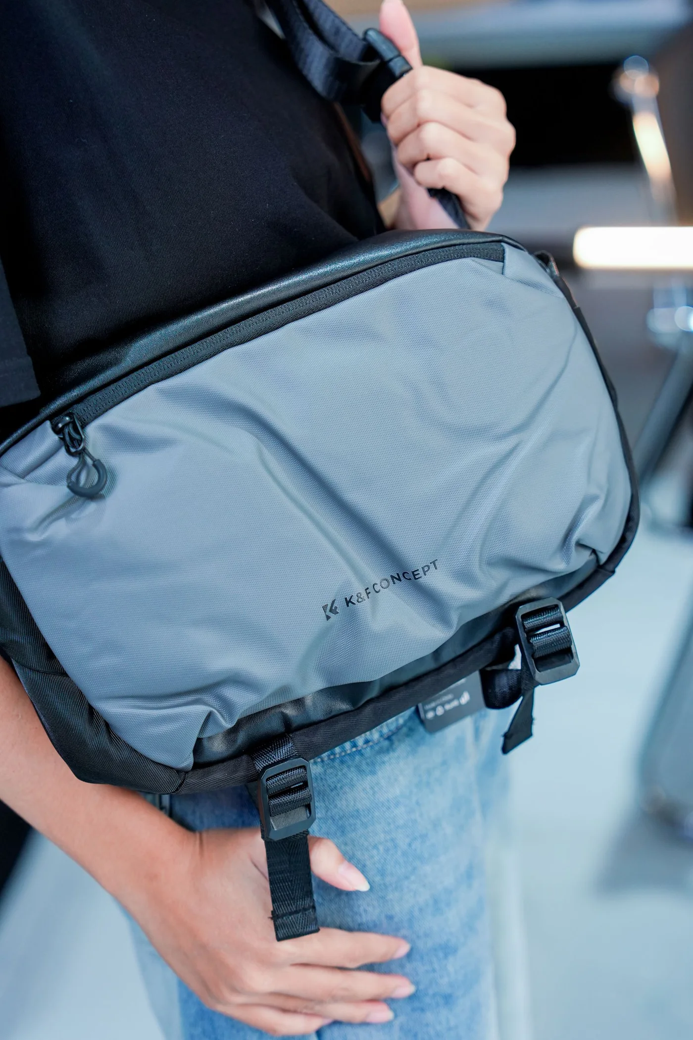 A close view of a blue messenger bag worn over casual clothing.
