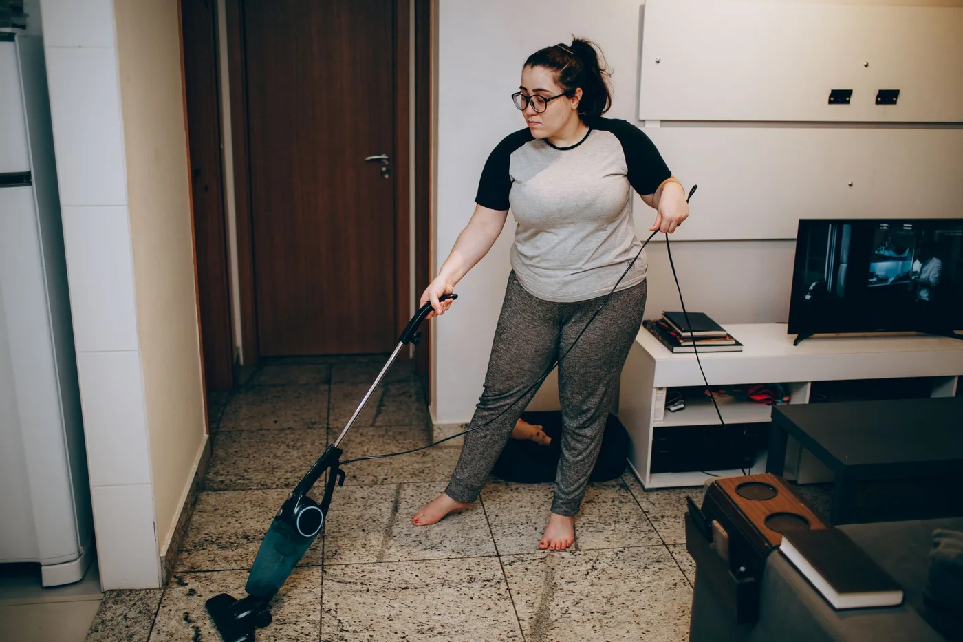 A woman vacuuming the floor in her living room.