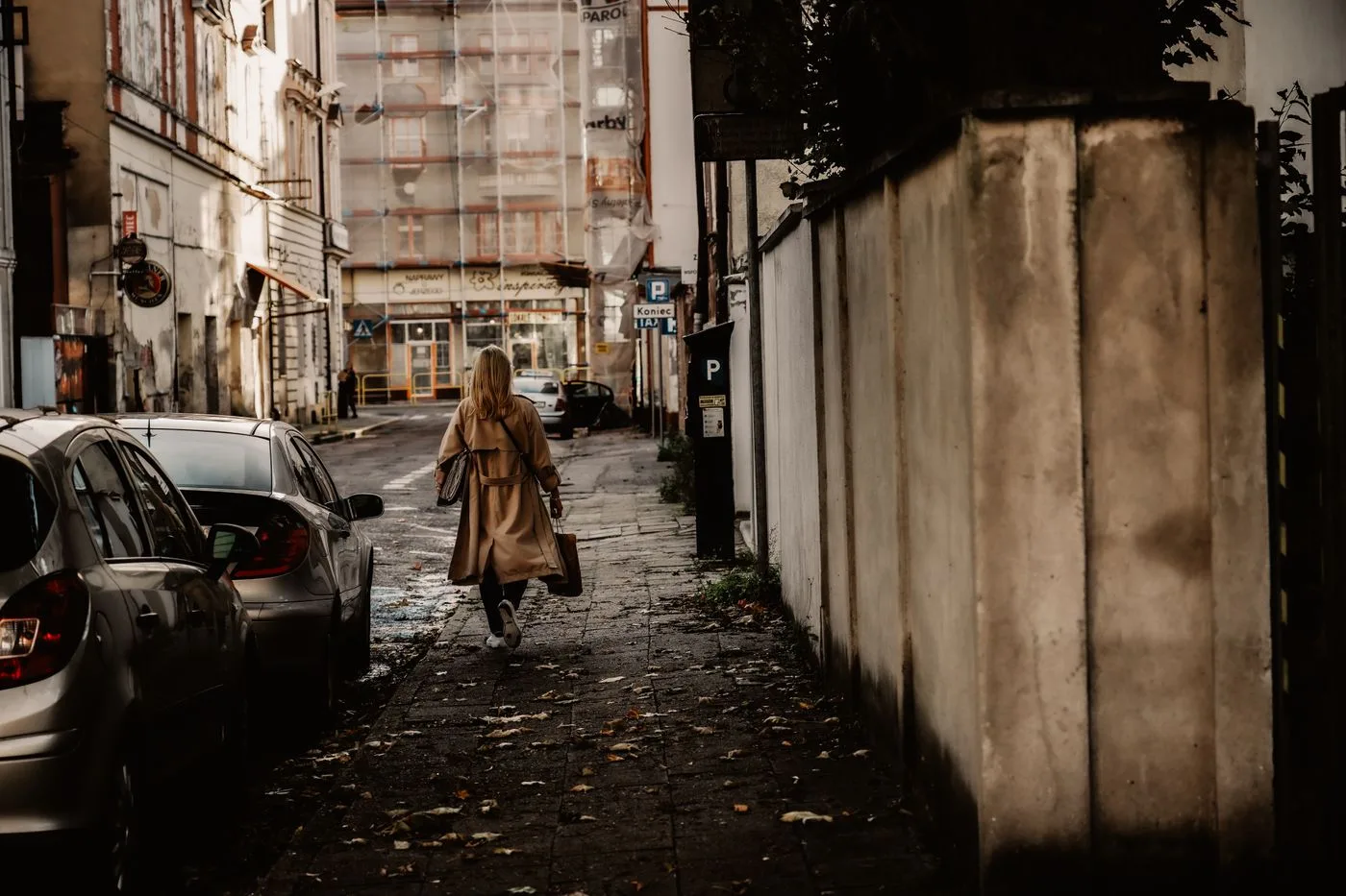 Woman wearing a long coat in an urban alley