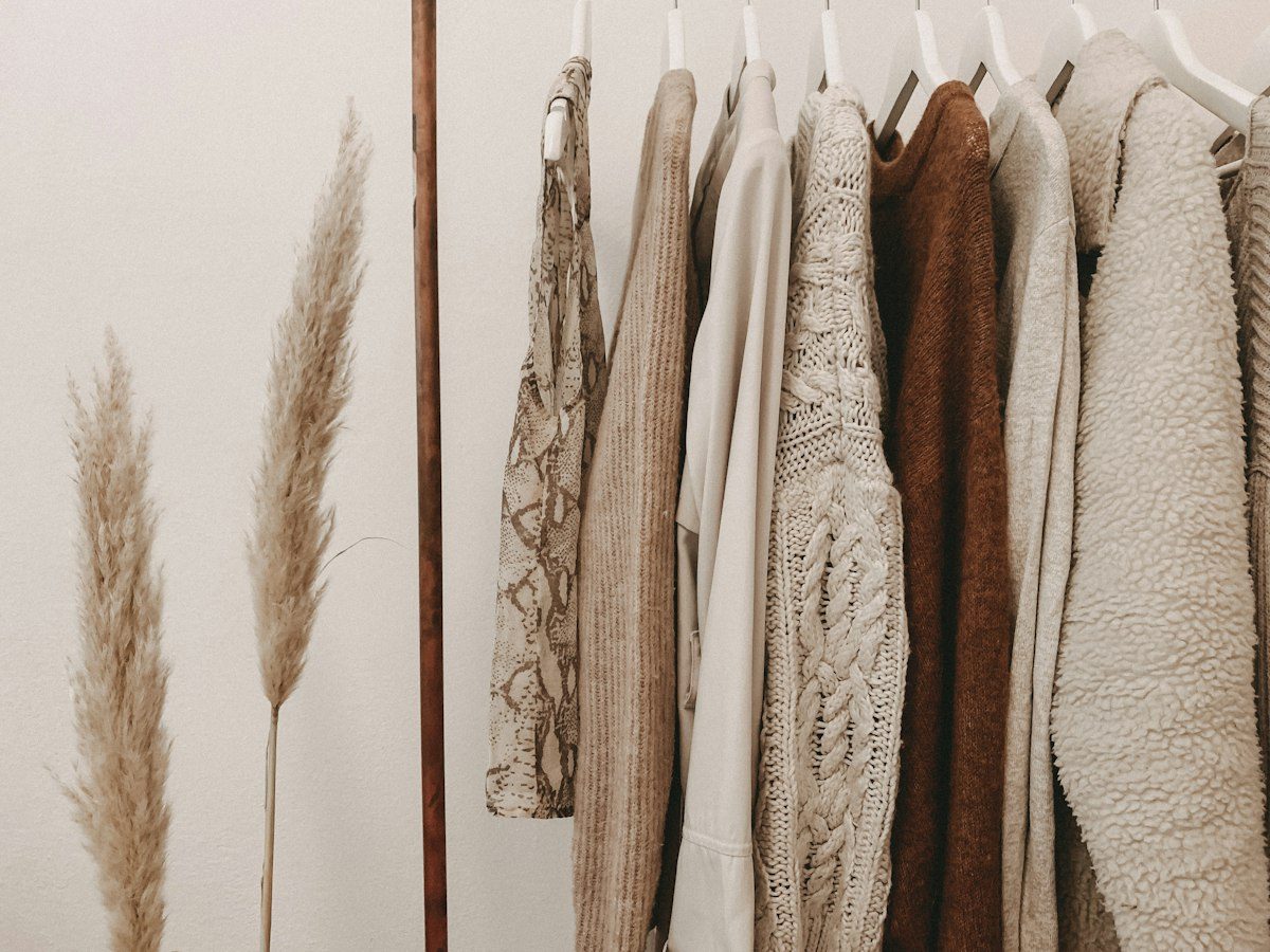 Neutral-toned clothing arranged on a rail at home
