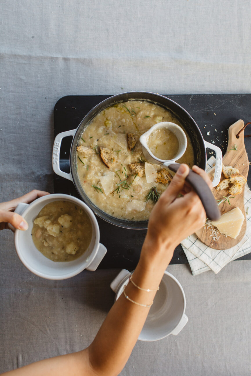 serving white bean cauliflower soup from large pot