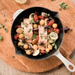 mediterranean baked salmon on serving tray in pan