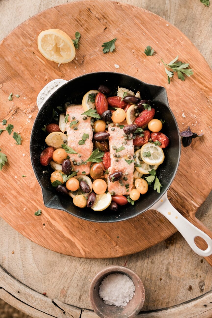 mediterranean baked salmon on serving tray in pan