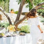 summer table setting ideas, Camille Styles summer dinner party table in backyard with trees, dancing, dance, twirling