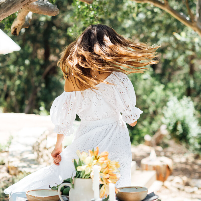 dance, celebrate, twirl-summer table setting ideas, Camille Styles summer dinner party table in backyard with trees, white dress_ovulatory phase
