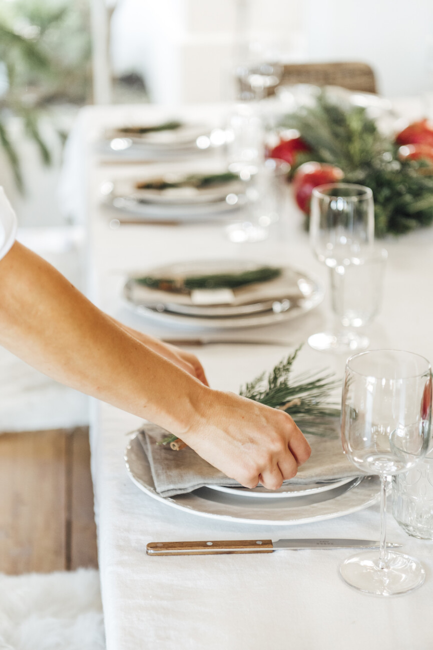simple christmas table setting ideas-scandinavian inspired holiday tabletop with evergreen and pomegranates-camille setting table