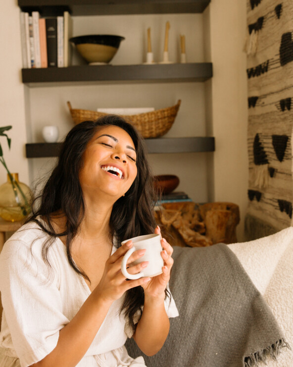 Woman smiling drinking tea_tea for menstrual cramps