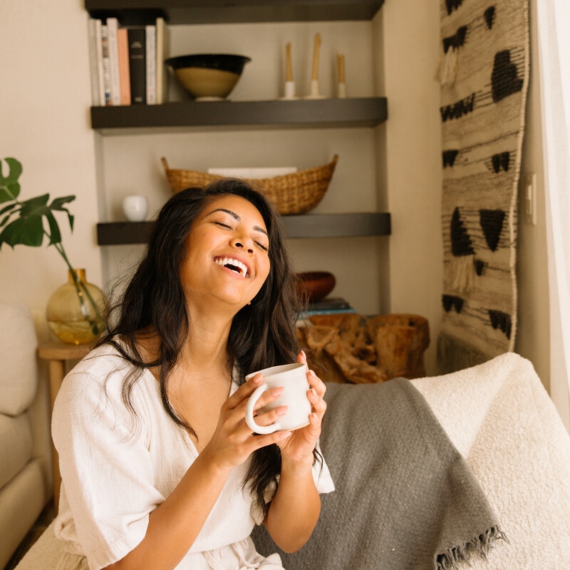 Woman smiling drinking tea_tea for menstrual cramps