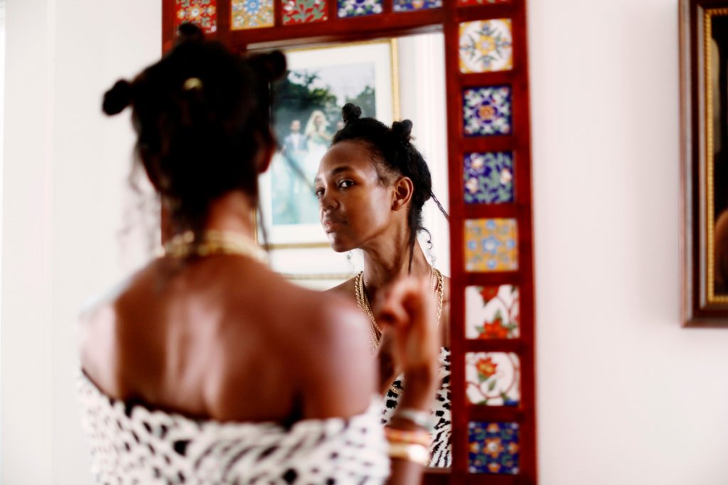 Megan O’Neill does her hair in the bathroom mirror_natural products for curly hair