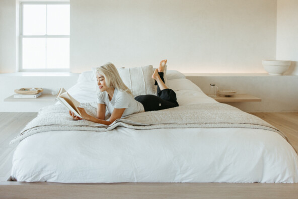 Woman reading feel-good book in bed.