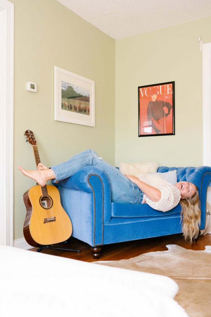 Model Beth Hitchcock laughing on the couch in her living room_natural products for curly hair