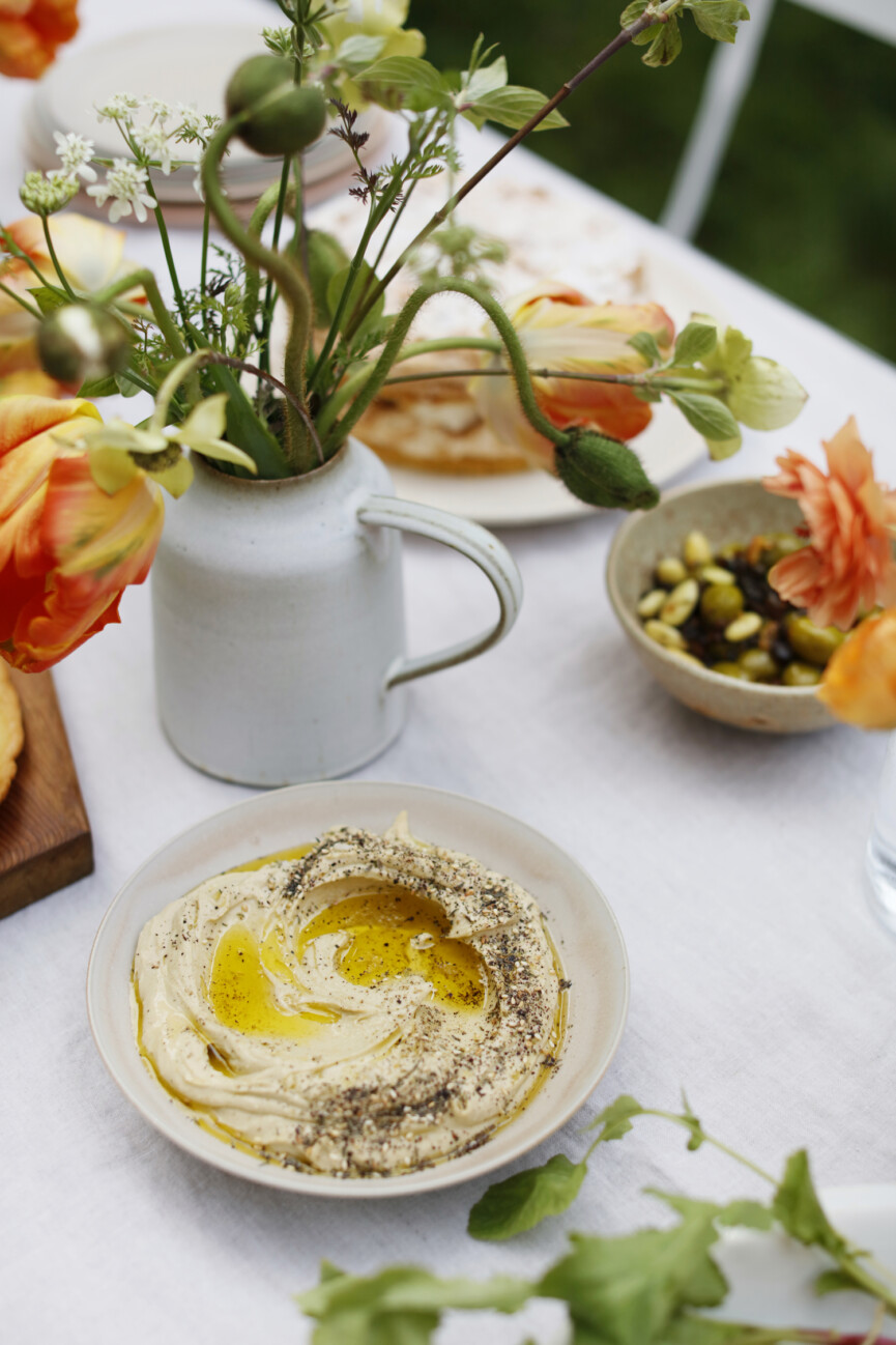 spring tablesetting for an outdoor party, flowers, tulips, hummus