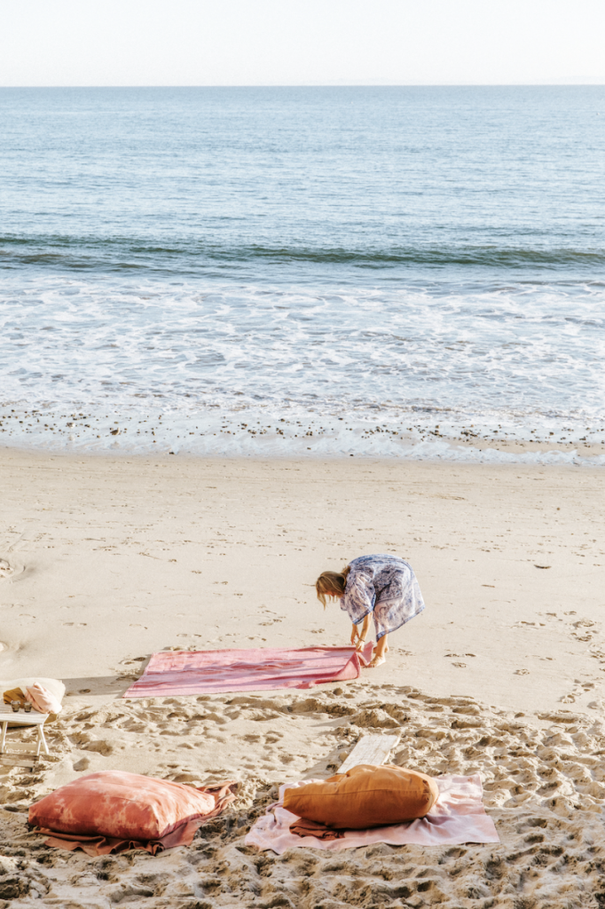 woman setting out towels on the beach_best new sunless tanners