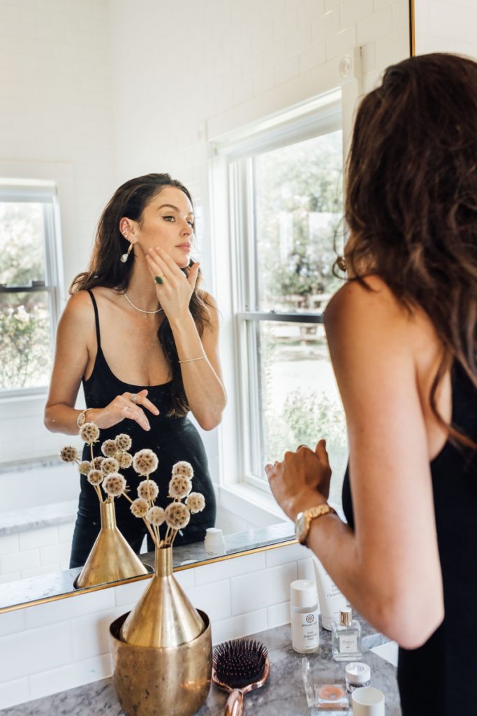 women applying skincare at the bathroom mirror. bakuchiol versus retinol.