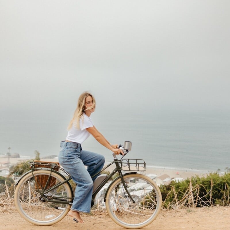 Woman biking by the ocean.