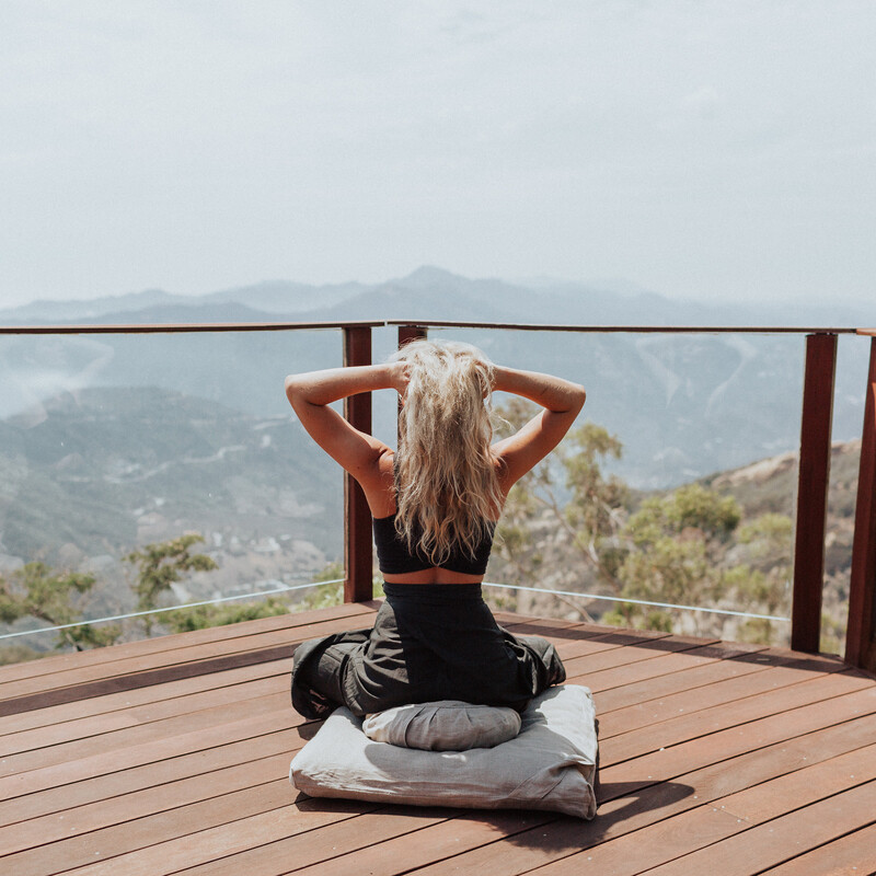 Blonde woman meditating on deck_how often should you poop