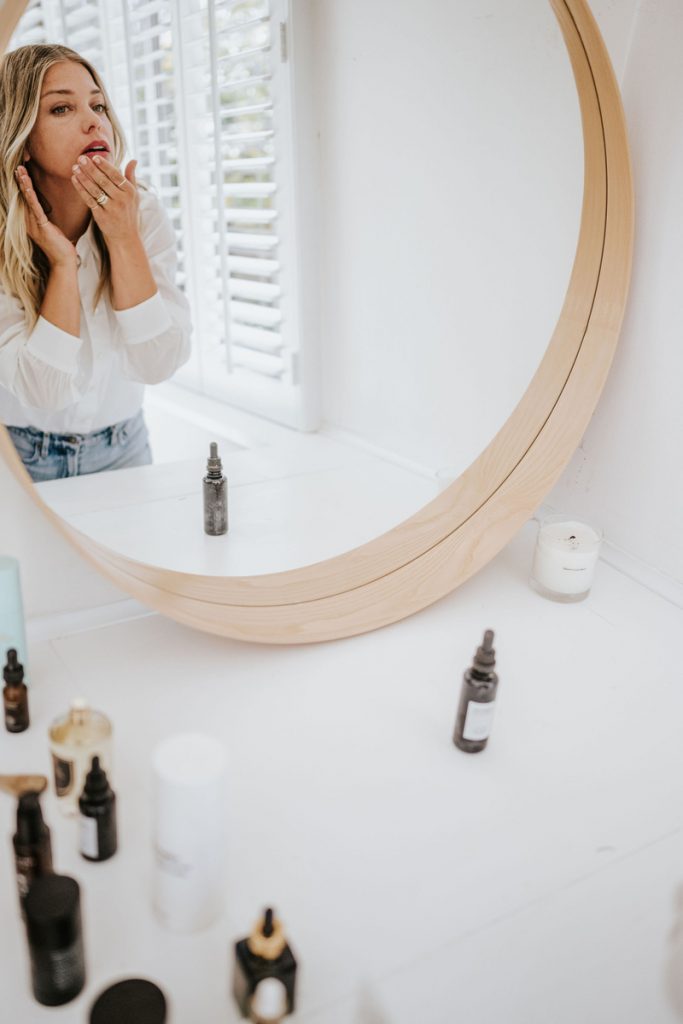 Janessa Leoné applying makeup in the mirror_non toxic makeup