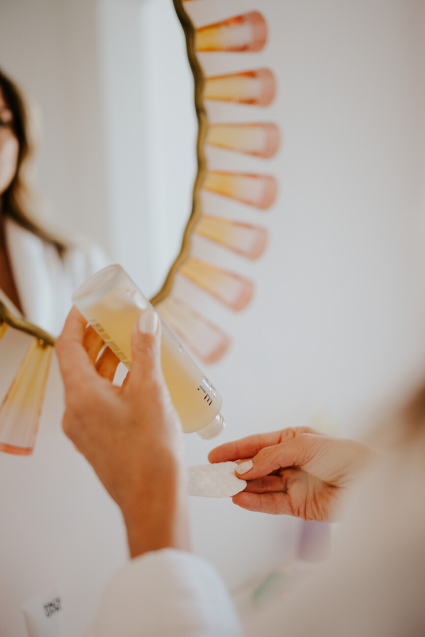 Woman applying face oil to hand.