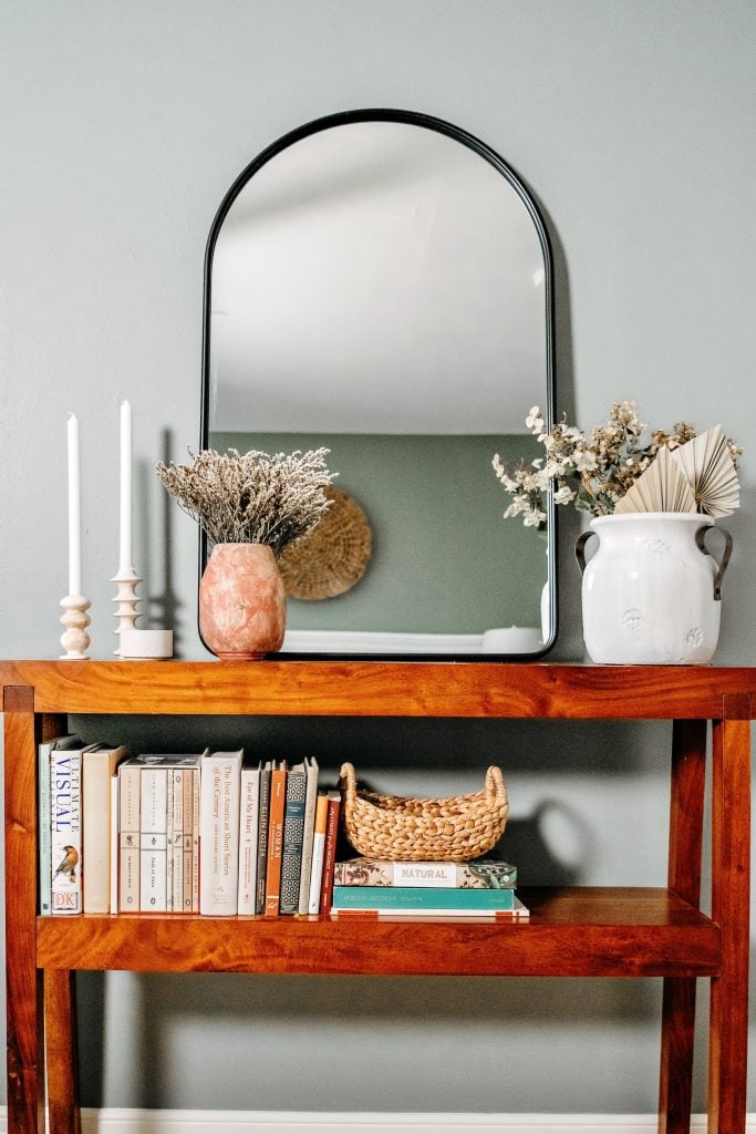grey walls with mirror above bookshelf_neutral paint colors for the living room