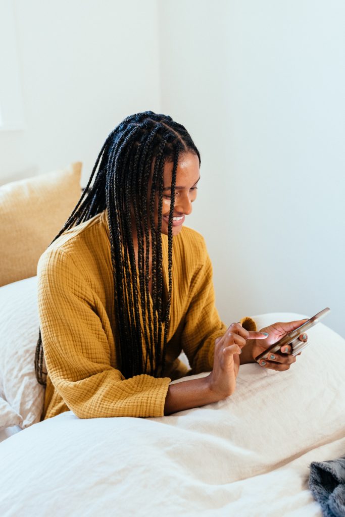 Shanika Hillocks using phone in bed_best home gadgets