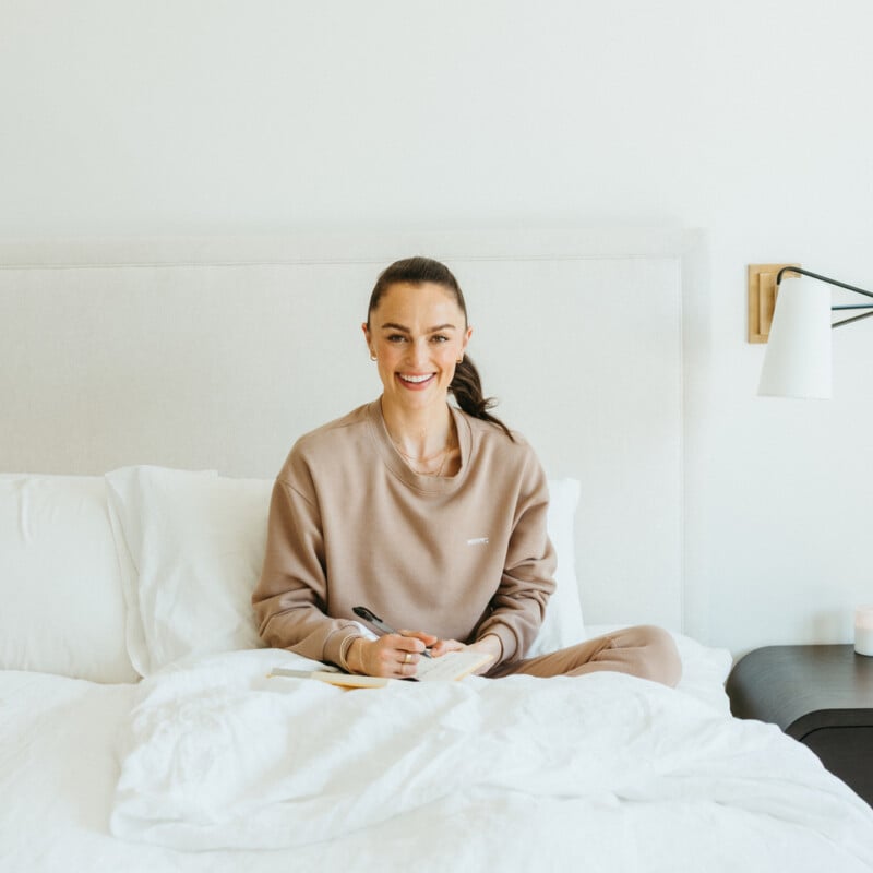 Woman journaling in bed.