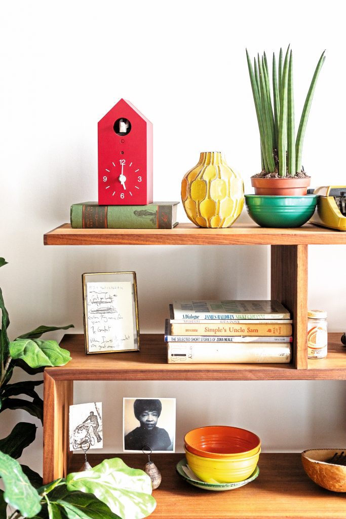 Eclectic bookshelf with photos and art.