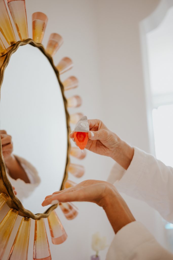 Inge Theron applying skincare in mirror_best glycolic acid serums