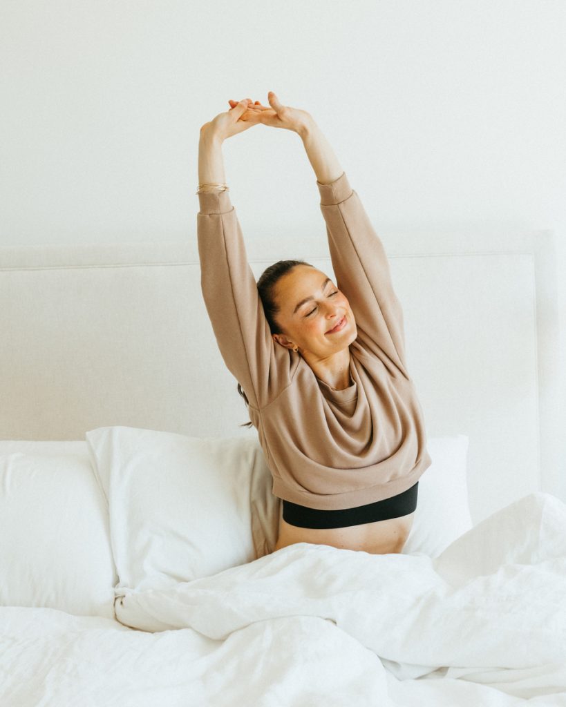 Megan Roup stretching in bed