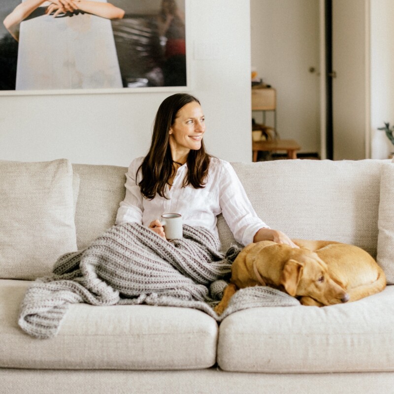 woman sitting on couch with dog