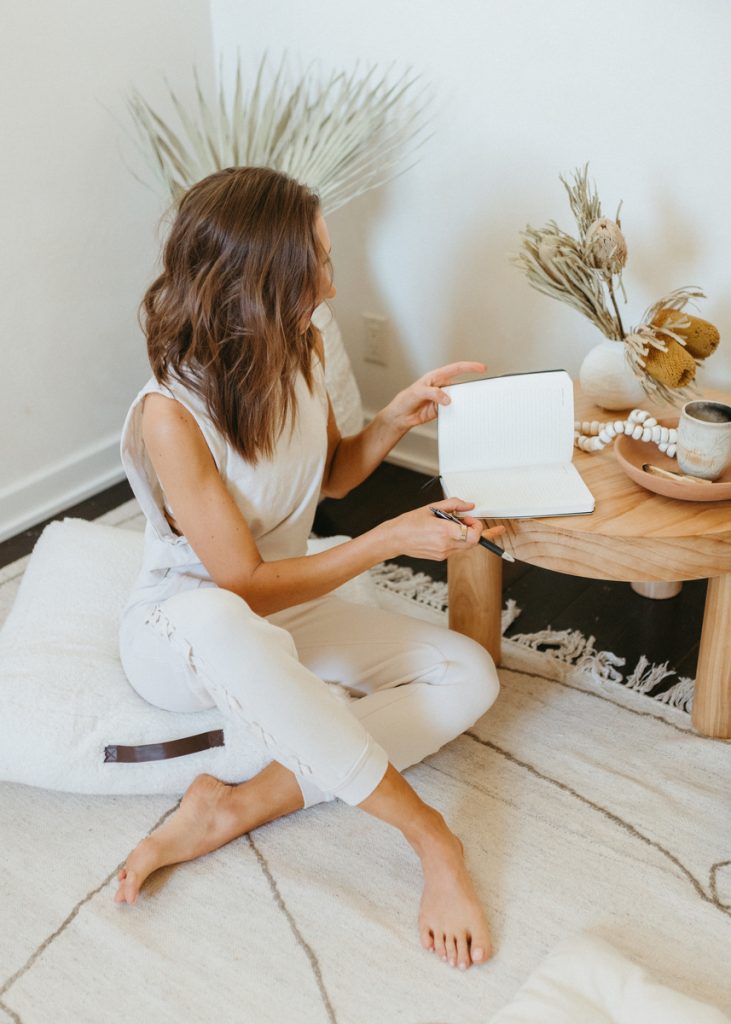 Woman journaling in meditation space.