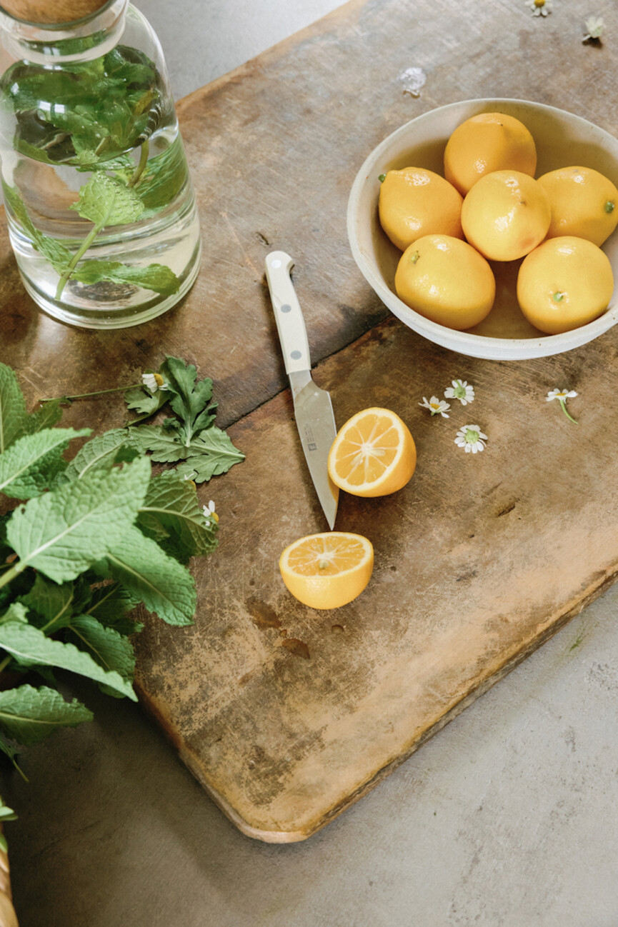 Slicing lemons on cutting board.