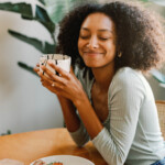 Woman drinking coffee and eating breakfast.