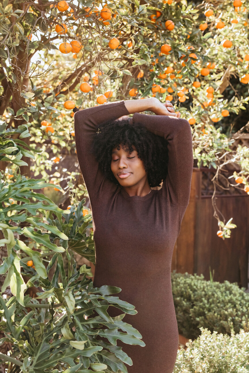 Woman outside wearing brown dress.