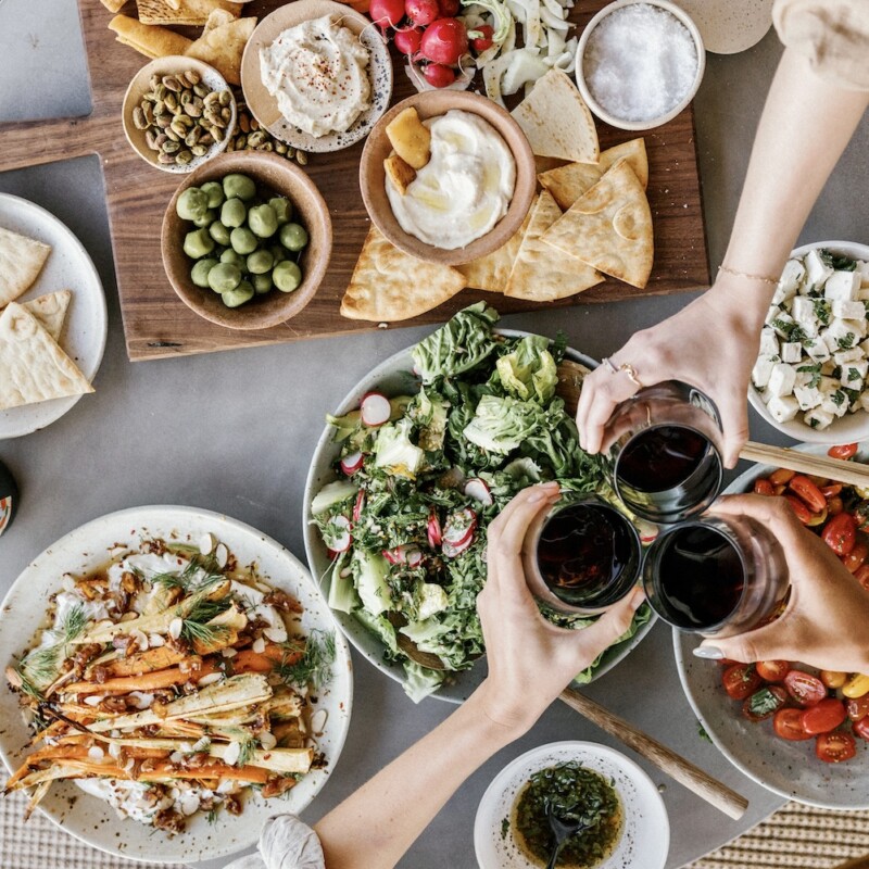 blood sugar travel tips-cheersing, food, dinner party