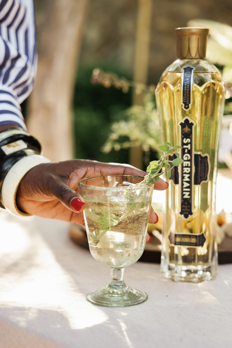 hand holding a st germain cocktail at apero