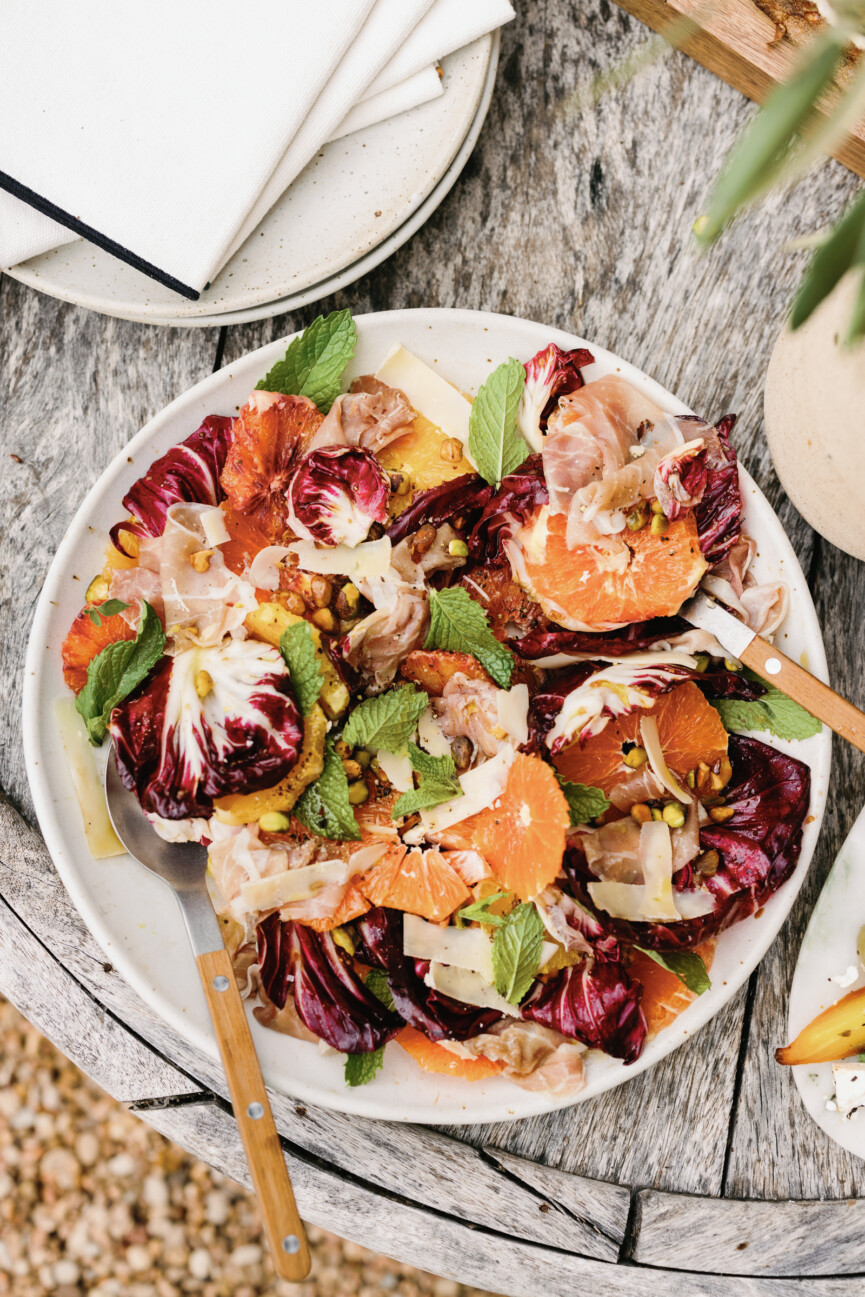 raddichio citrus prosciutto salad with mixing forks