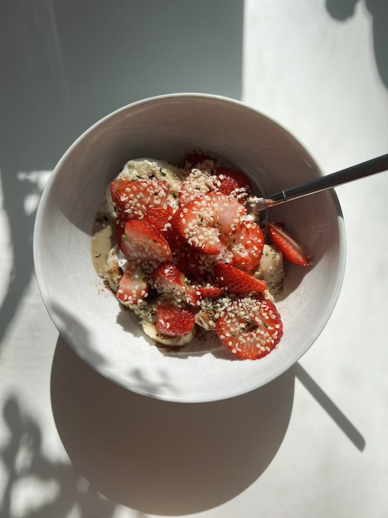 Greek yogurt bowl with strawberries, honey, and granola.