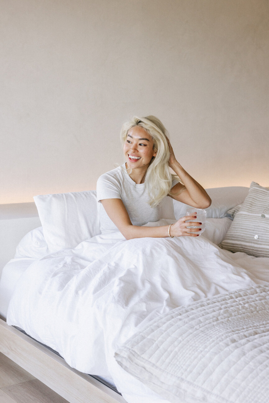 Woman drinking water in bed.