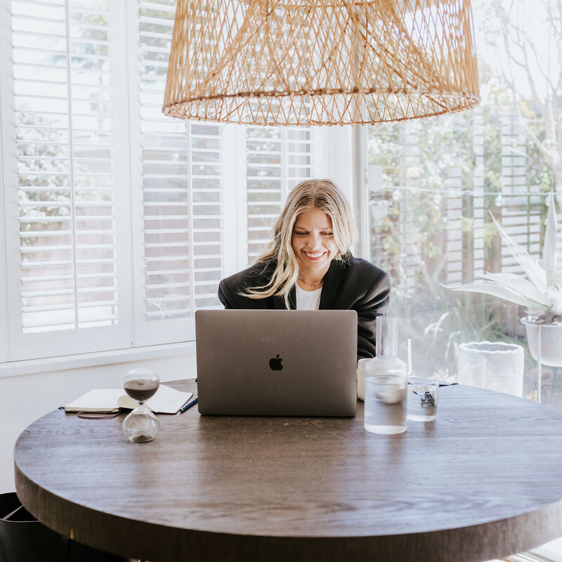 A blonde woman working on laptop.