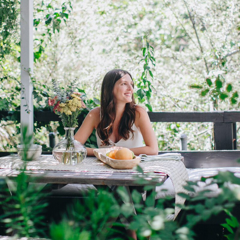 Ashley Neese sitting at outdoor dining table outside.
