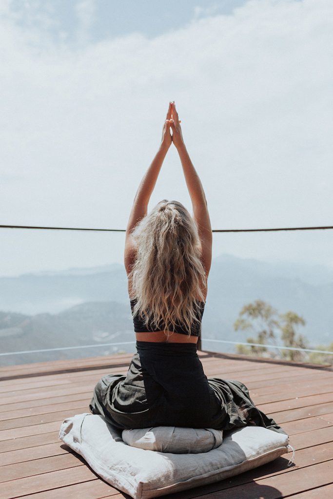 Blonde woman doing yoga outside.