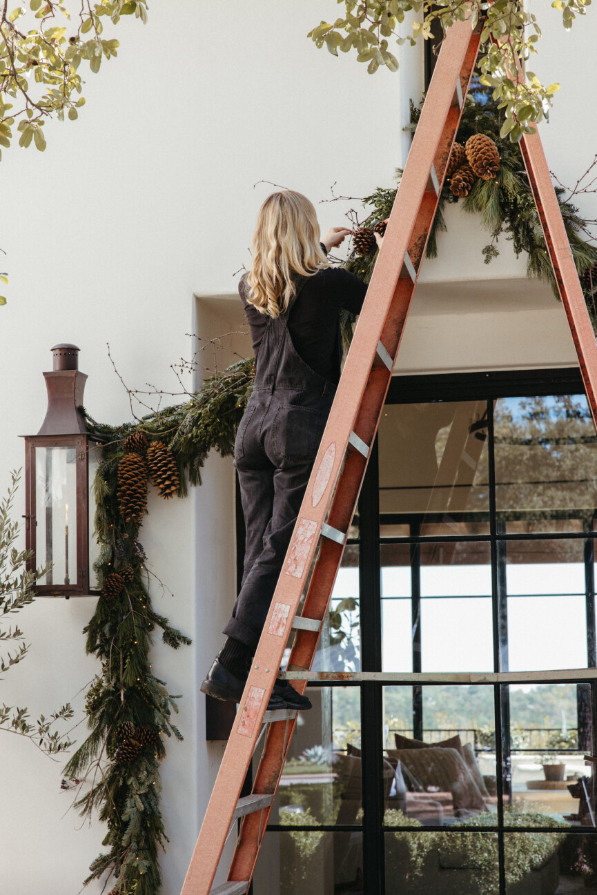 Camille Styles Holiday Decor 2023-Christmas front porch decor with evergreen garland and casa zuma holiday wreath and candles