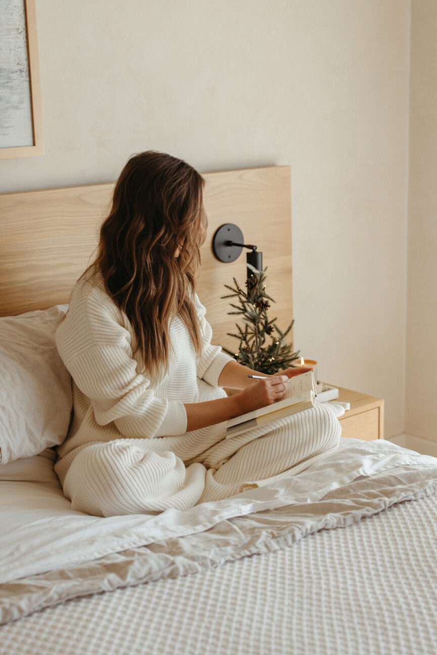 Woman journaling in bed.