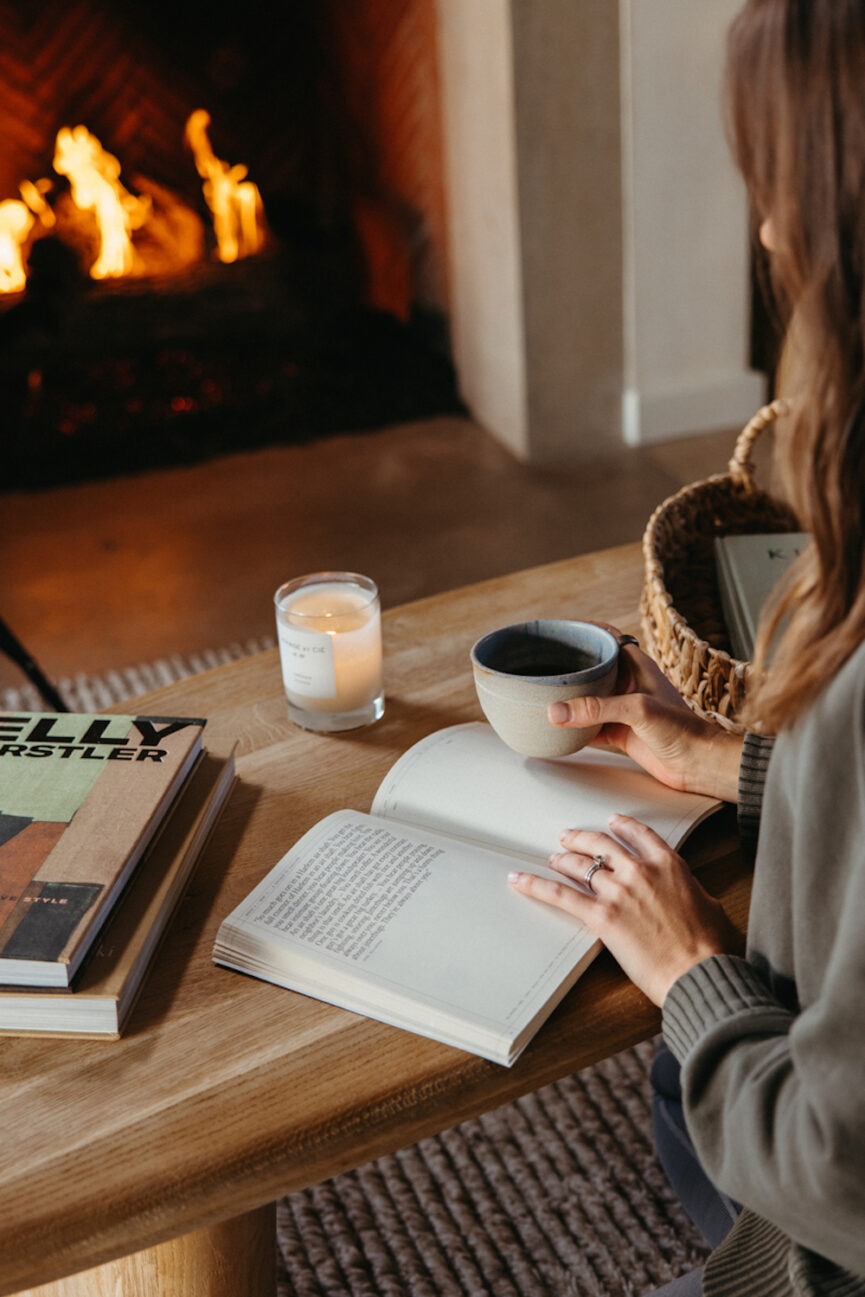 Reading by fireplace.