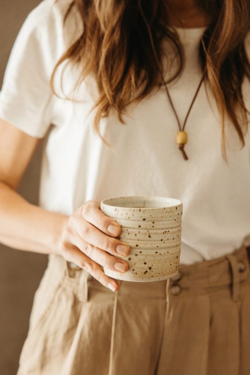 Woman holding ceramic mug.