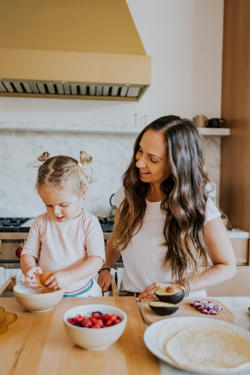 Mother daughter cooking in kitchen.