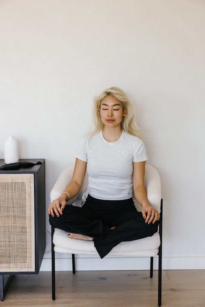 Woman meditating on chair.