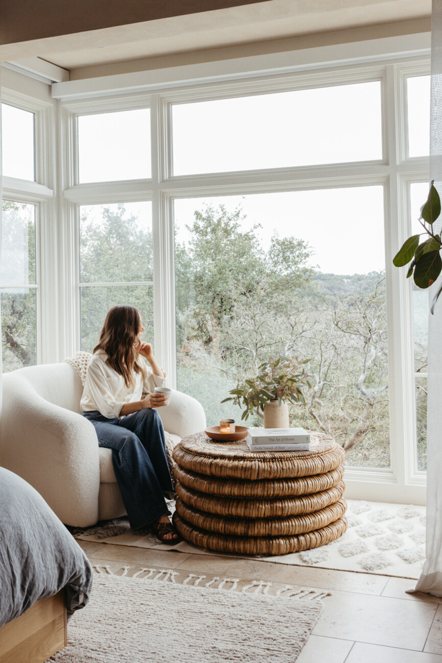 Camille Styles sitting at coffee table - decluttering checklist.