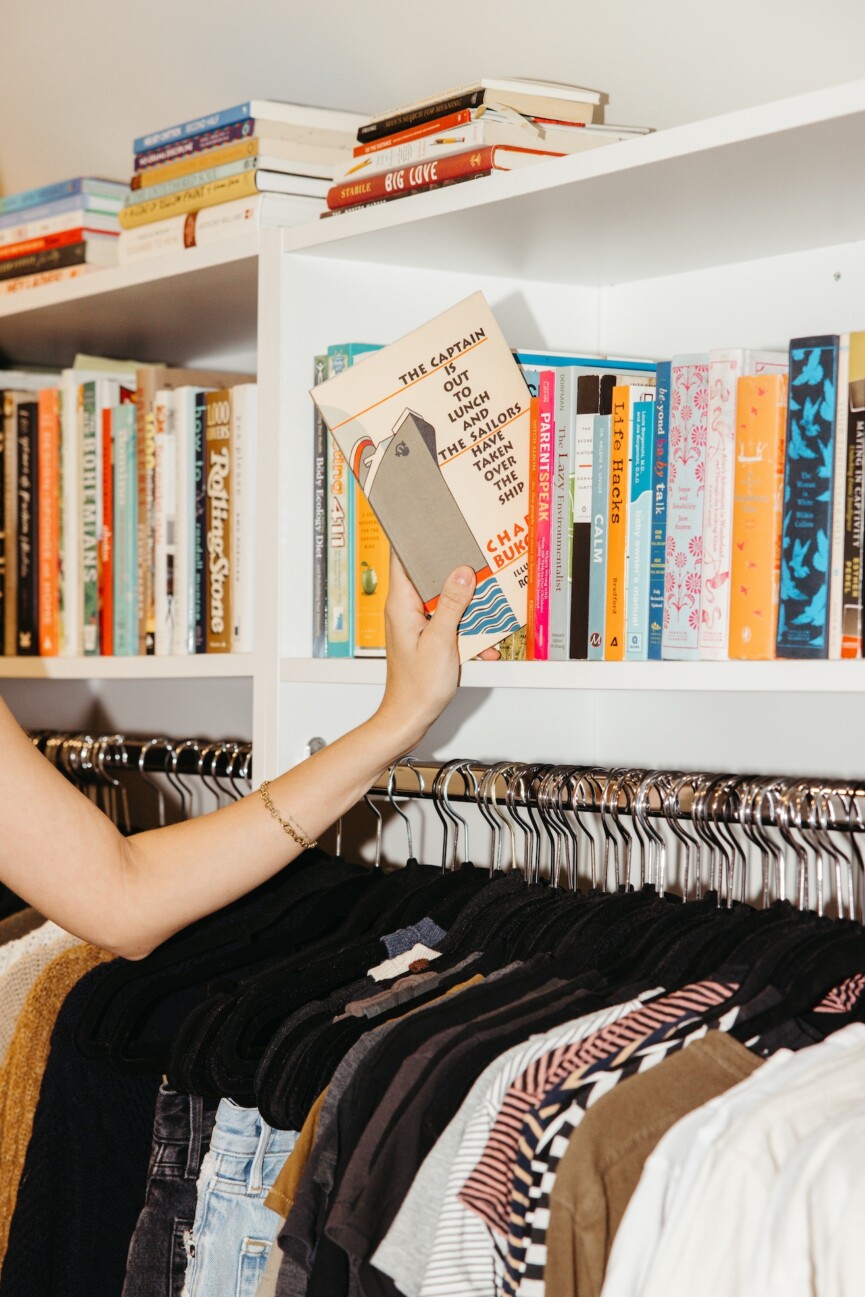 hand reaching for book on bookshelf