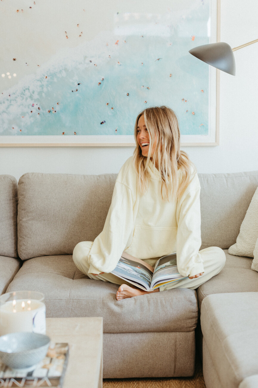 Mary Ralph reading on couch.